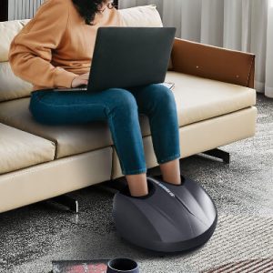 A woman using a foot massager while working