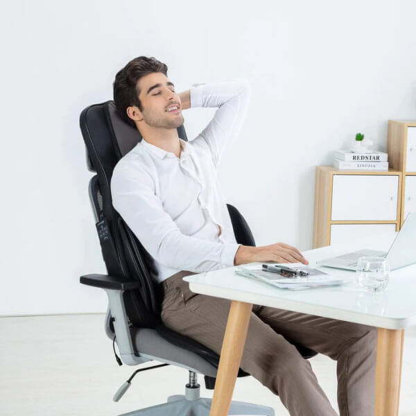 A man using a back massager in his office