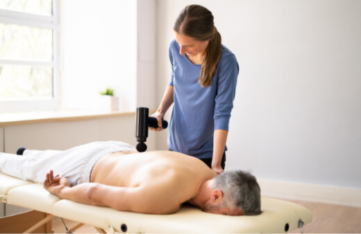 A woman using a massage gun