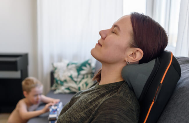 A woman using a neck and back massager